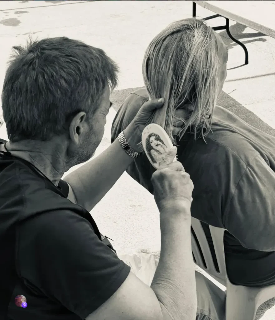 voluntario de la casa de la esperanza peinando el cabello de una persona en un taller de cuidado personal y dignidad